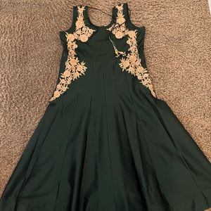 Dark green gown/anarkali. Comes with net dupatta and churridar pants